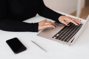 a woman typing on a laptop