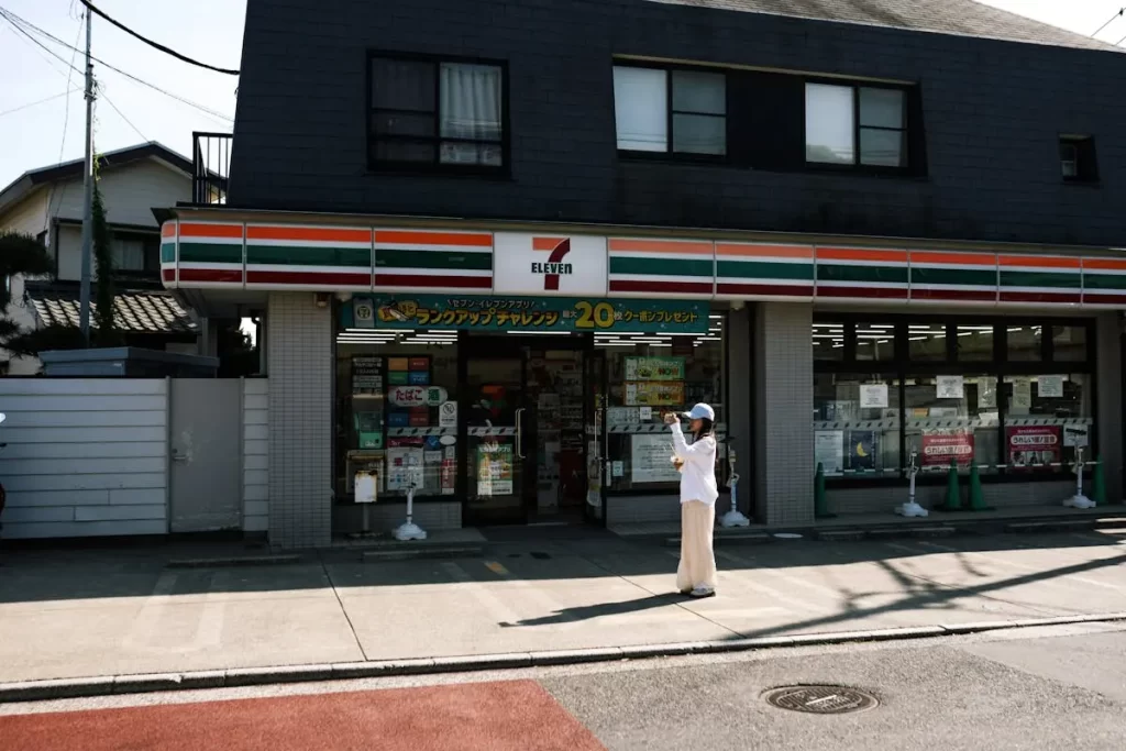 Person standing outside a 7-eleven convenience store in japan taking a photo