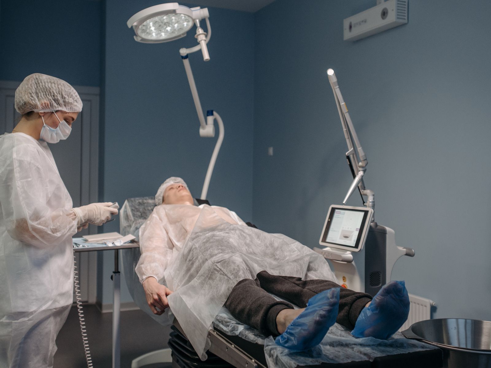 Physician performing an aesthetic laser treatment in a clinic with a laser system