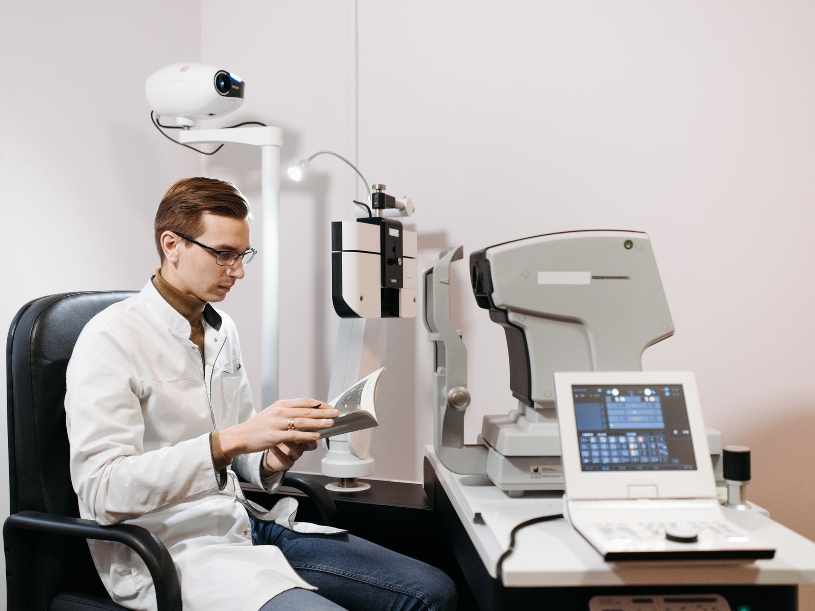 Optometry Equipment Financing 1 Optometrist in an exam room with an autorefractor, slit lamp and other optometry equipment