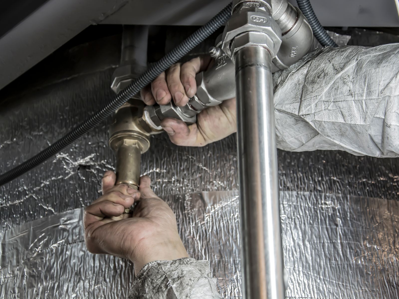 Business Loans &Amp; Equipment Financing For Plumbers 1 Plumber tightening a steel pipe fitting during an installation