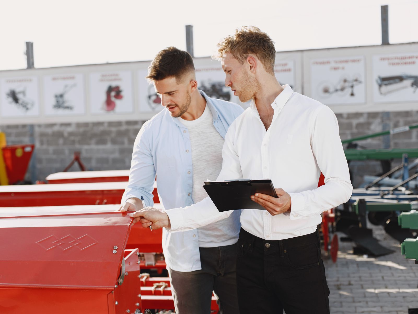 What Is Equipment Vendor Financing? 1 Equipment dealer reviewing financing options on a tablet with a customer at the dealership
