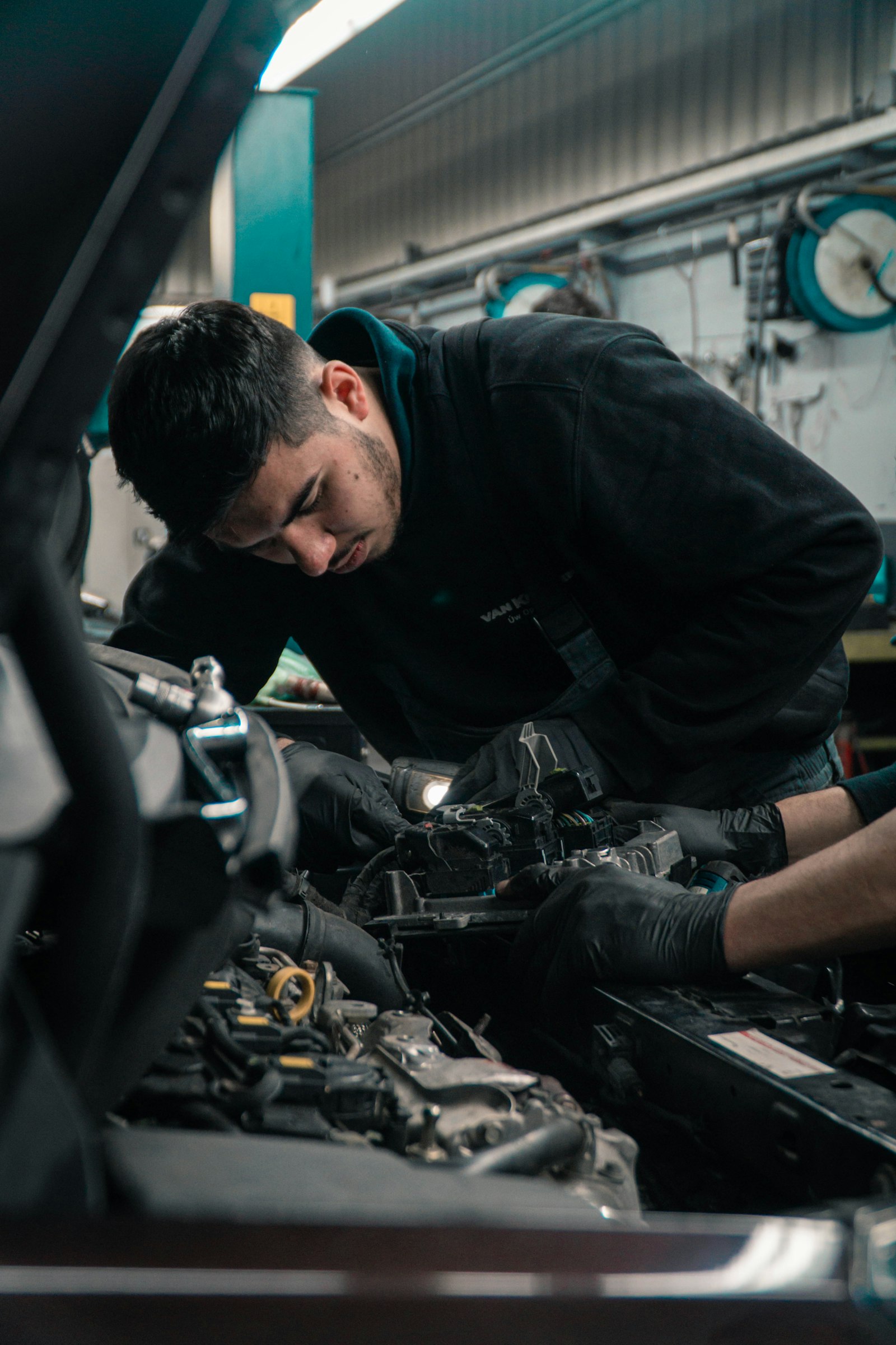 Auto repair technician working under the hood in a repair shop