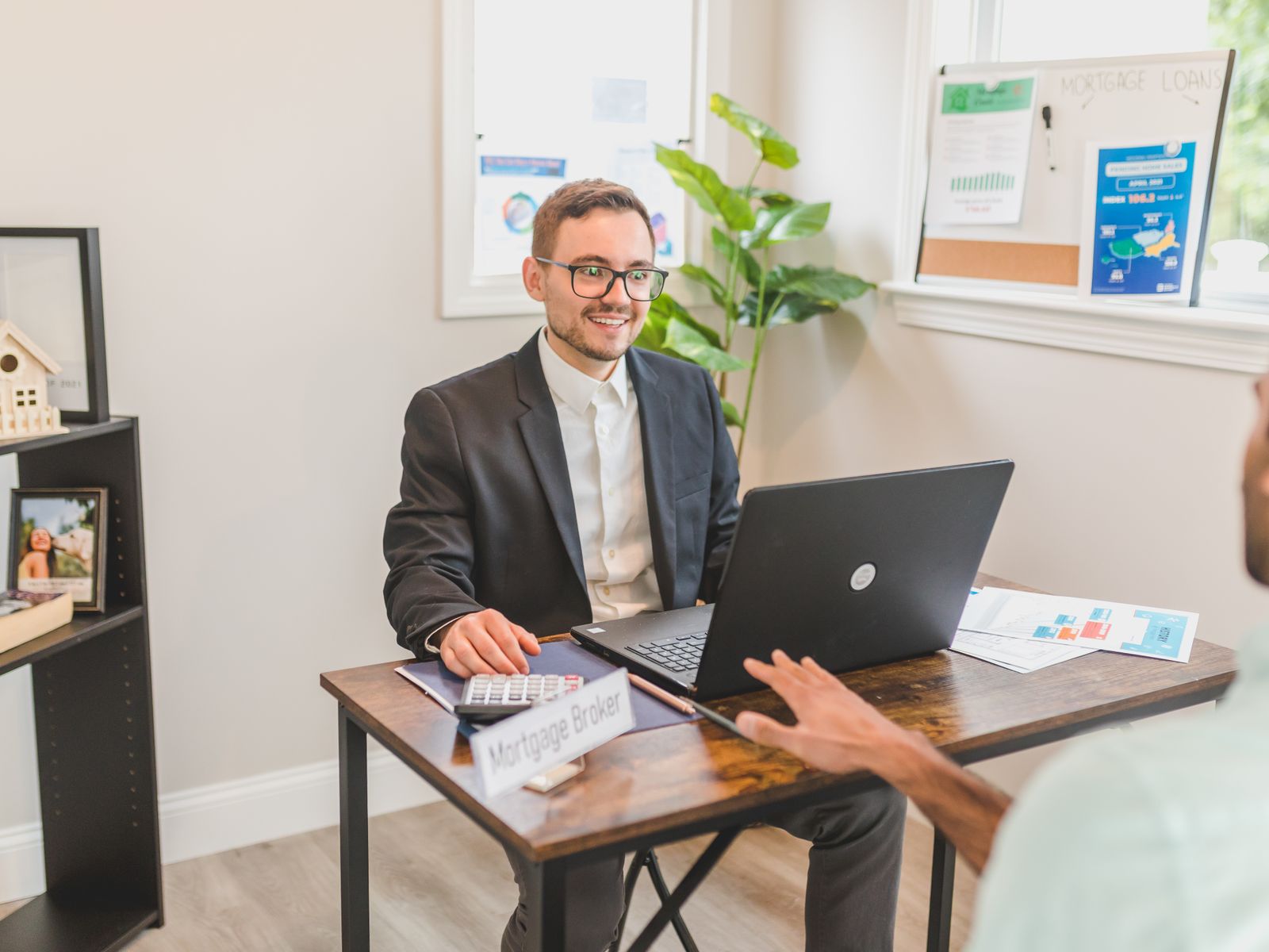 Business Loan Broker 1 Business loan broker reviewing financing options with a client at his desk