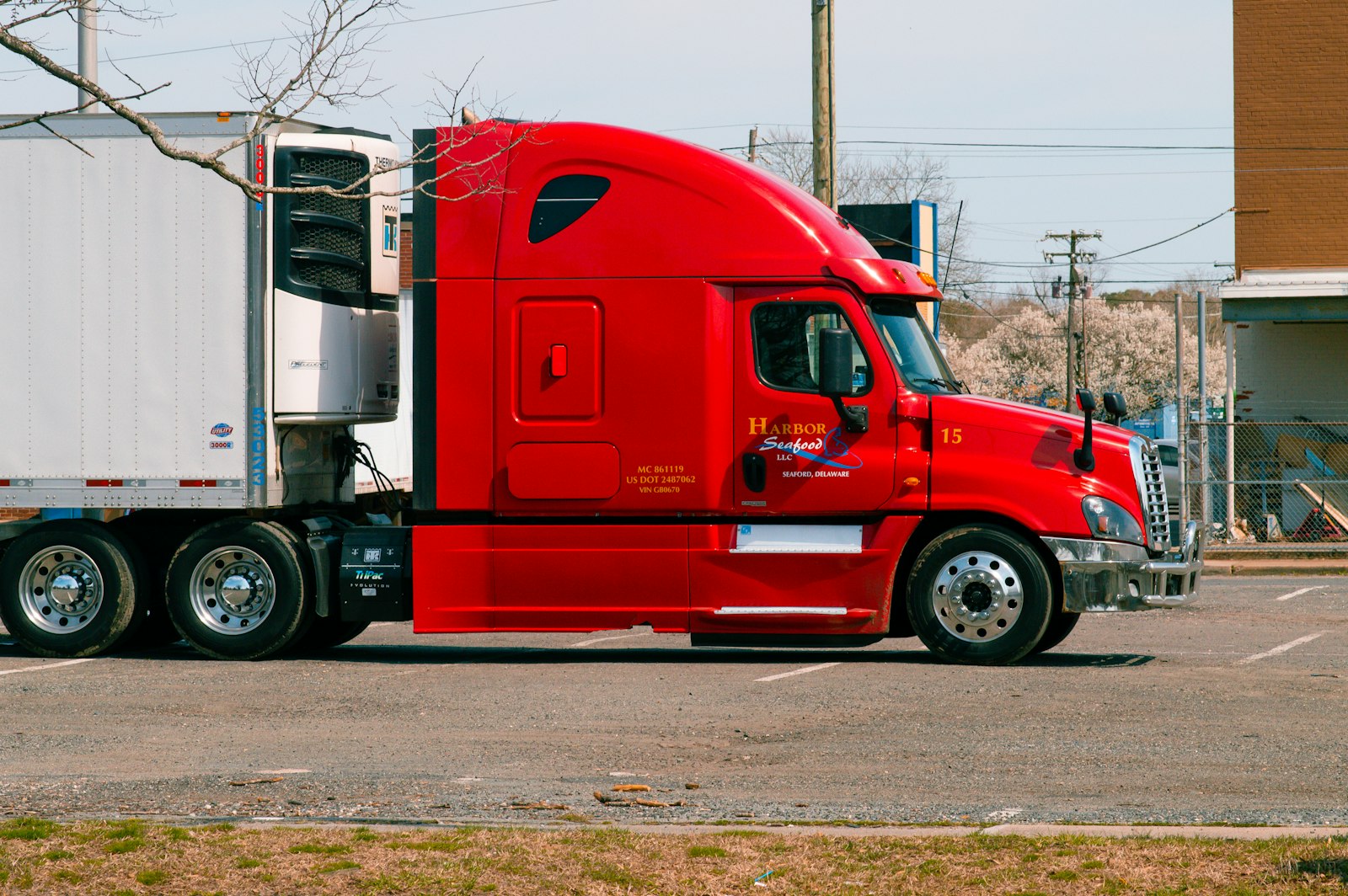 Red freightliner tractor hooked to a refrigerated reefer trailer with a thermo king unit