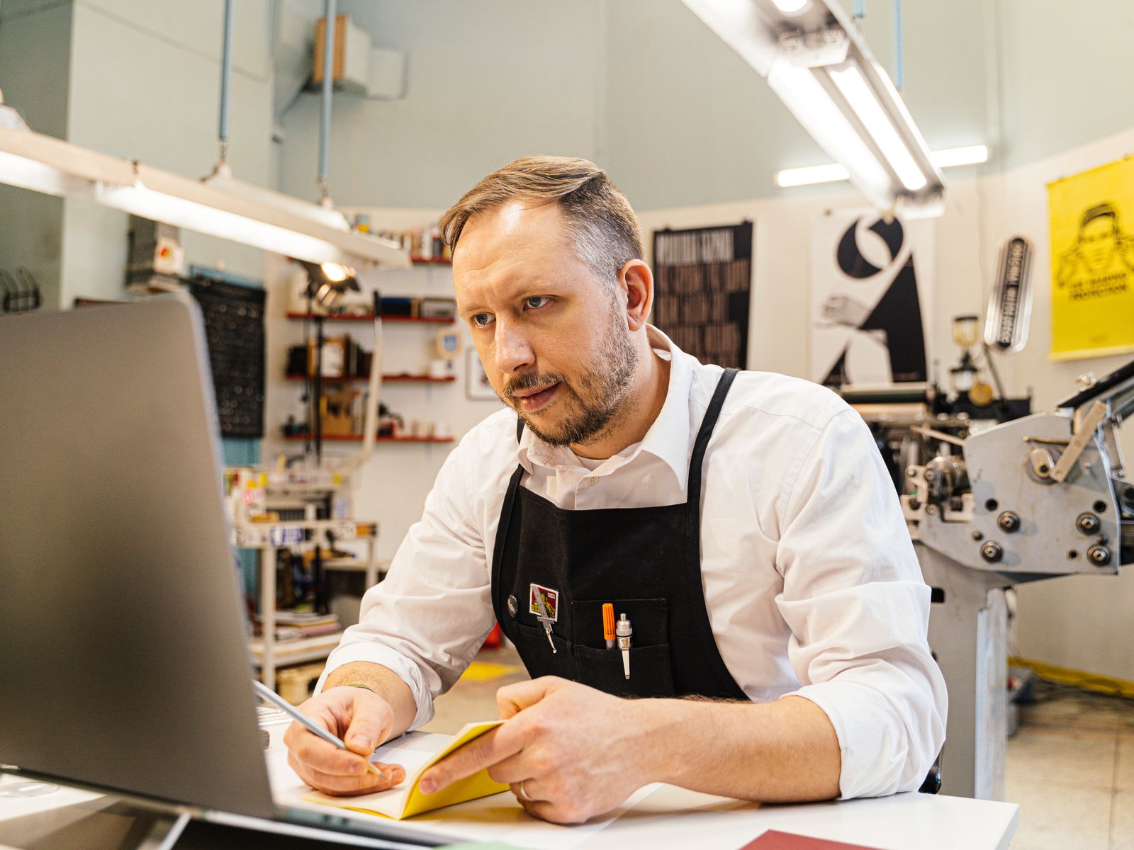 Small Business Loans 1 Print shop owner reviewing orders on his computer - small business loans
