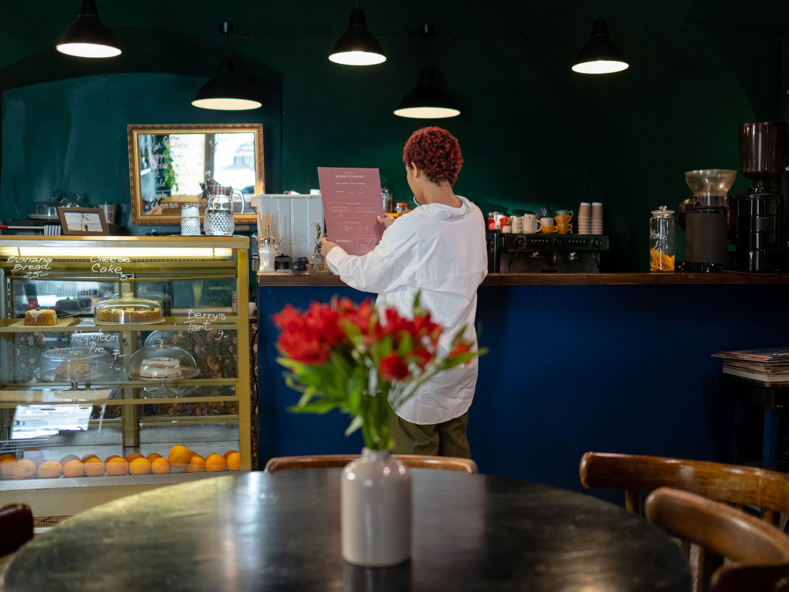 Cafe owner reading an order at her counter - unsecured business loans